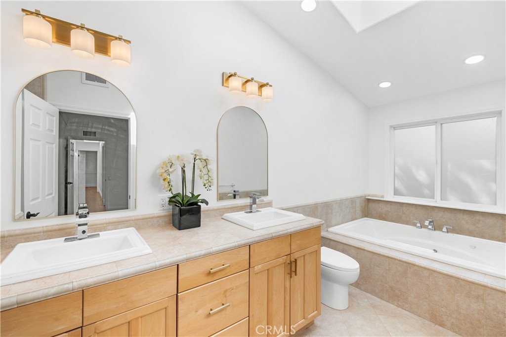 26096 Adamor Road Calabasas, CA 91302 - Photo 34 of 61 Primary bathroom with double vanity, vaulted ceiling and skylight.