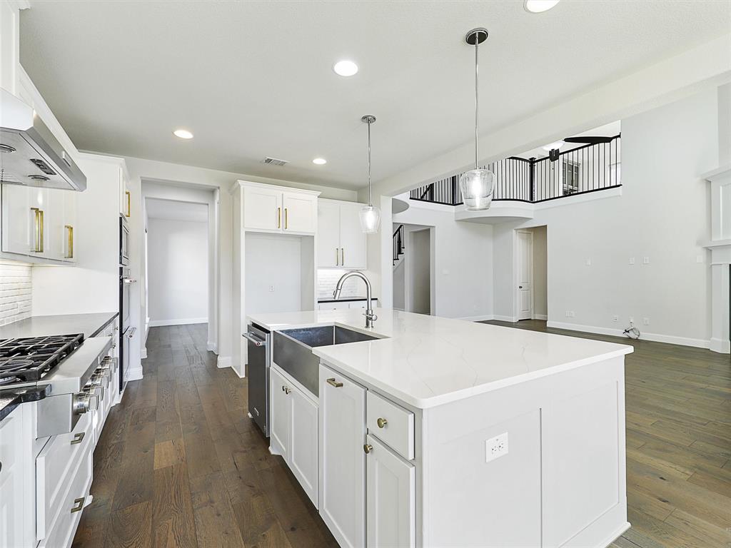 8473 Gerbera Daisy Road Frisco, TX 75035 - Photo 13 of 39 a kitchen with a stove a sink a refrigerator and chairs