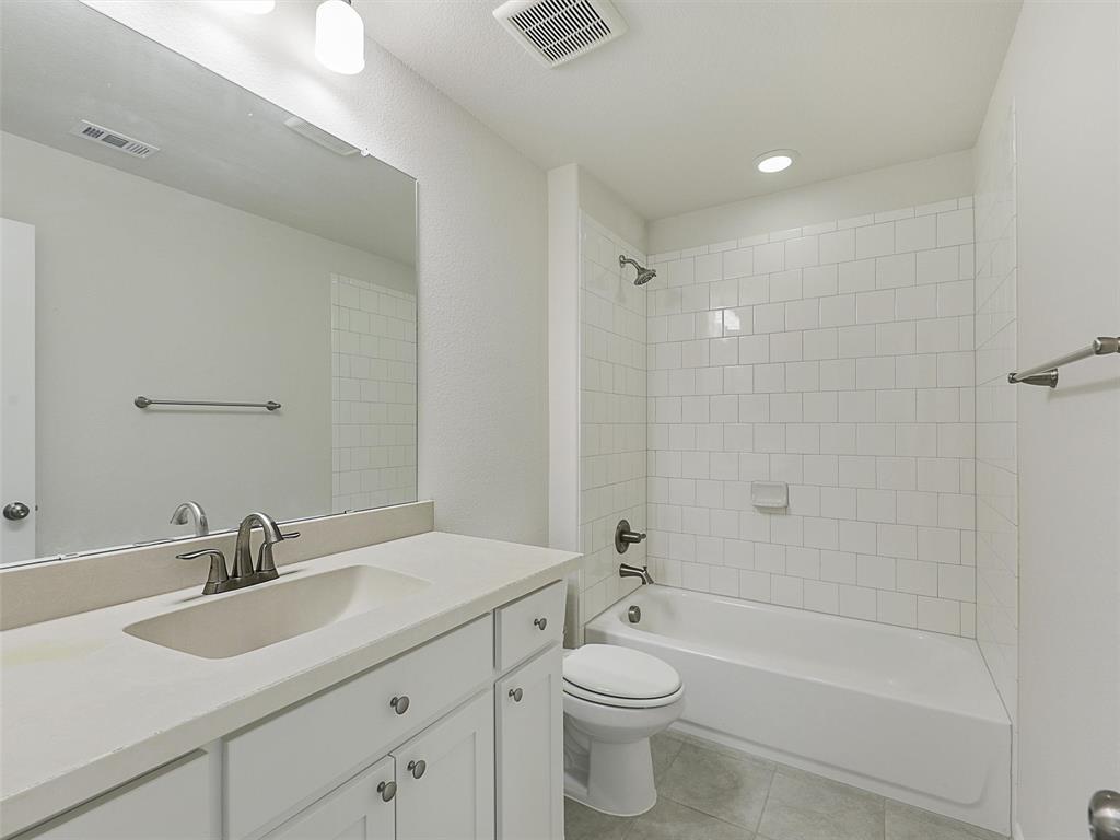 8473 Gerbera Daisy Road Frisco, TX 75035 - Photo 31 of 39 a bathroom with a toilet a sink a mirror a bathtub and vanity