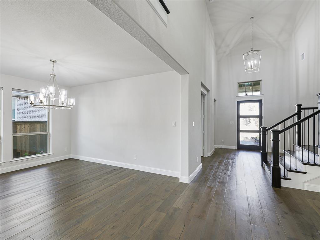 8473 Gerbera Daisy Road Frisco, TX 75035 - Photo 9 of 39 a view of a room with wooden floor staircase and a kitchen