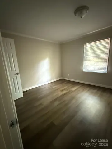 en empty room with wooden floor and windows