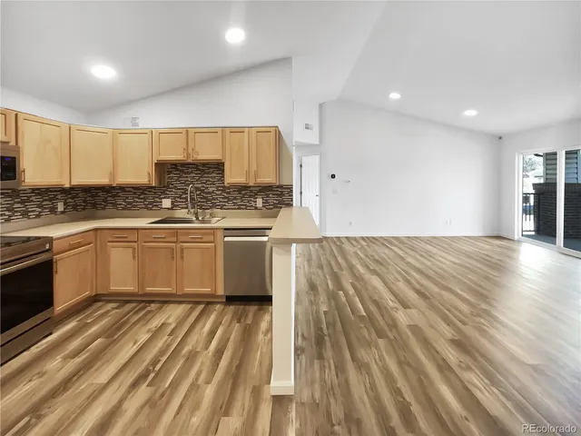 a kitchen with stainless steel appliances granite countertop a stove a sink and a refrigerator