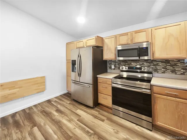 a kitchen with stainless steel appliances a stove microwave and refrigerator