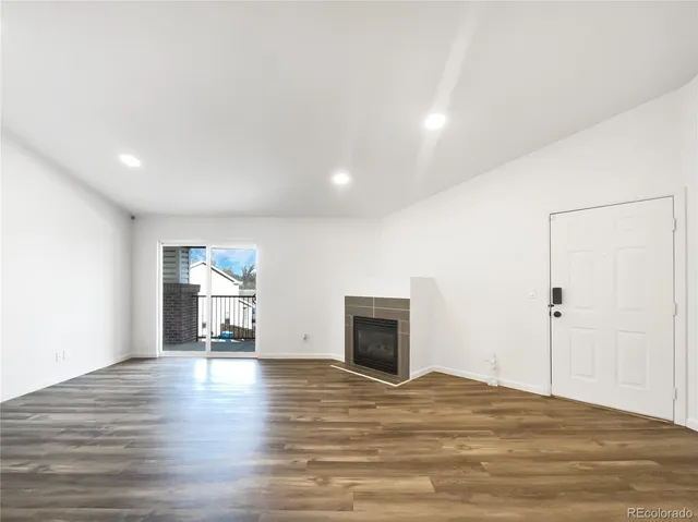 a view of empty room with wooden floor and fireplace