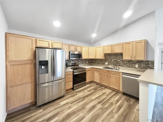 a kitchen with stainless steel appliances a refrigerator sink and cabinets