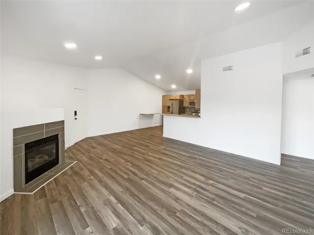 a view of empty room with wooden floor and fireplace