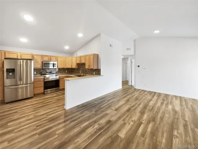 a kitchen with stainless steel appliances a refrigerator and a stove top oven