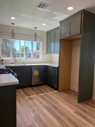 a kitchen with stainless steel appliances granite countertop a refrigerator and a sink