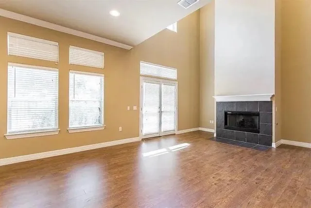a view of an empty room with a window and fireplace