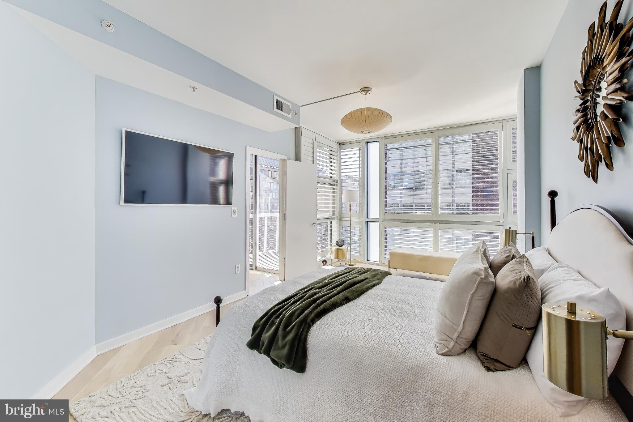 1300 13th Street Northwest, Unit 601 Washington, DC 20005 - Photo 22 of 35 A wall of windows and flat mount tv that conveys