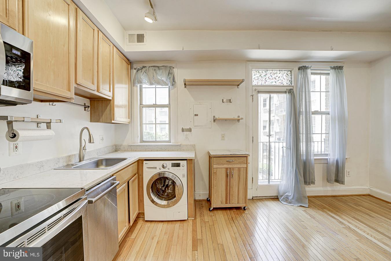 1401 Columbia Road Northwest, Unit 219 Washington, DC 20009 - Photo 10 of 33 a kitchen with a stove a sink and a refrigerator