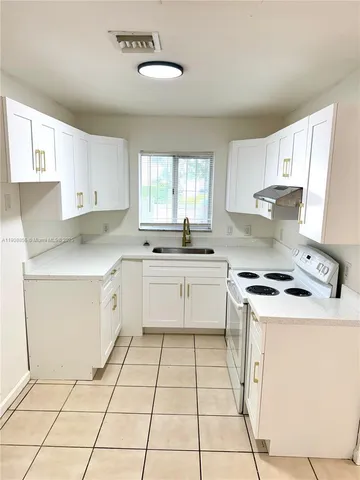 a kitchen with a stove sink and cabinets