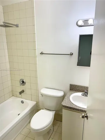 a white toilet sitting next to a bathroom sink and tub