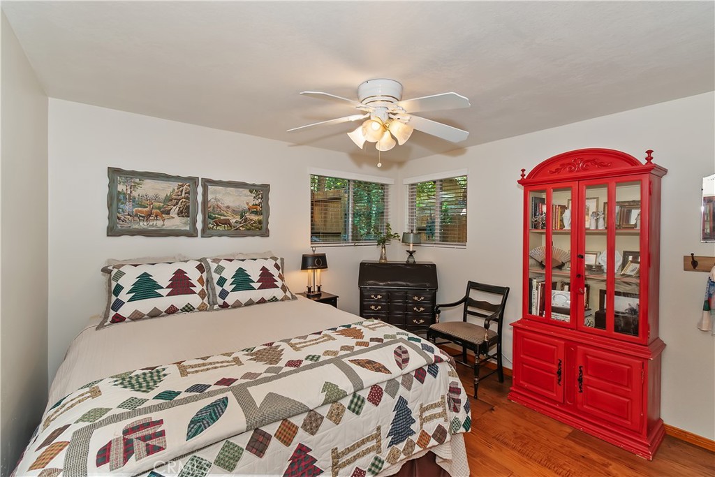 158 Golf Course Road Lake Arrowhead, CA 92391 - Photo 18 of 75 a bedroom with a bed and a chandelier