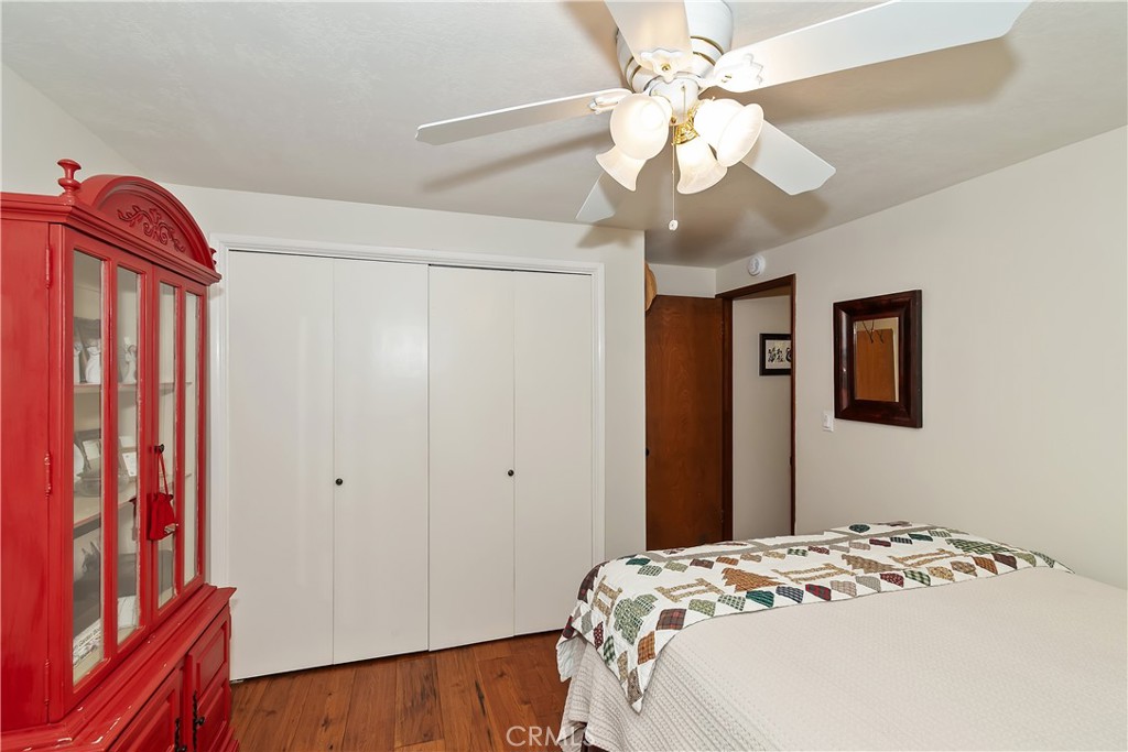 158 Golf Course Road Lake Arrowhead, CA 92391 - Photo 19 of 75 a bedroom with a bed and a chandelier