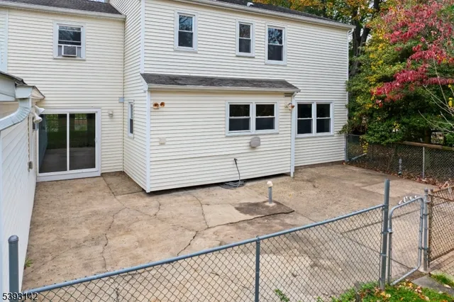 a view of a white house with wooden fence