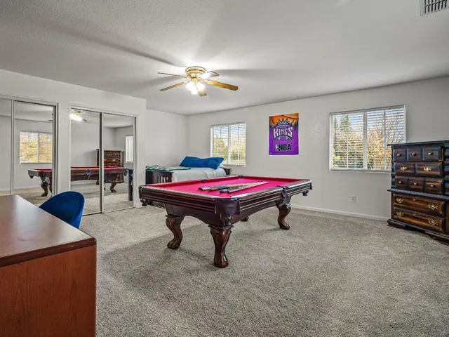 a room with furniture pool table and windows