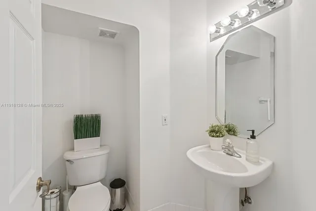 a bathroom with a sink toilet and a mirror