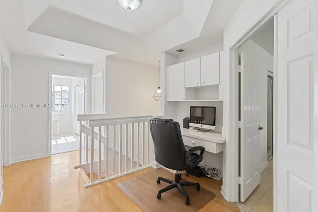 a view of a workspace with furniture and a window