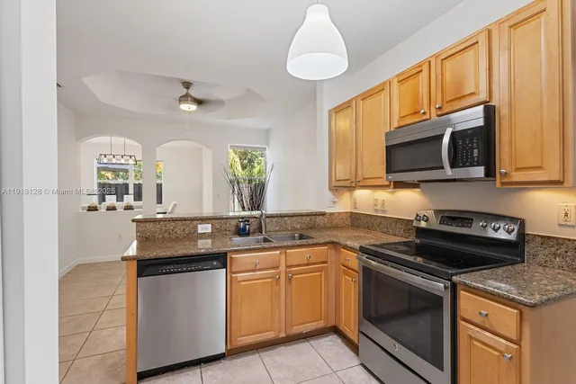 a kitchen with stainless steel appliances granite countertop a sink and a stove