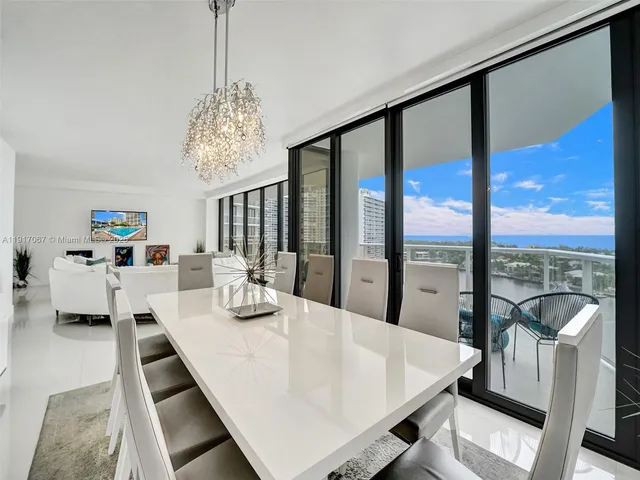 a view of a dining room with furniture a chandelier and wooden floor