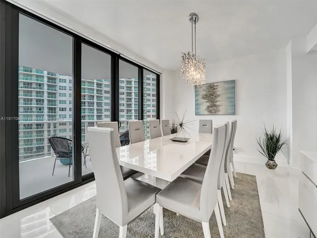 a kitchen with stainless steel appliances granite countertop a stove a sink a microwave a dining table and chairs with wooden floor