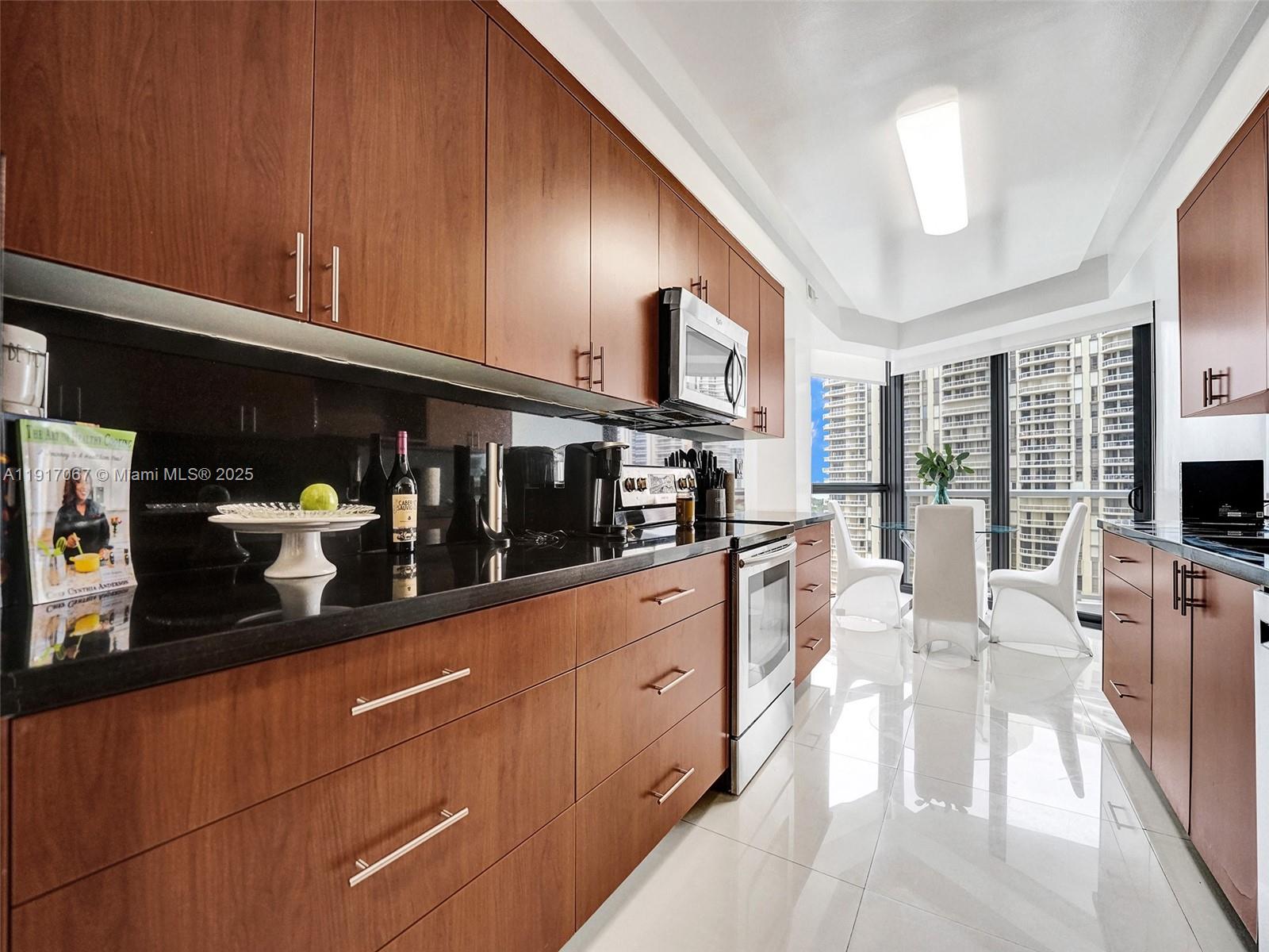 20281 East Country Club Drive, Unit 1114 Aventura, FL 33180 - Photo 29 of 87 a kitchen with stainless steel appliances kitchen island granite countertop a refrigerator a stove and a wooden cabinets