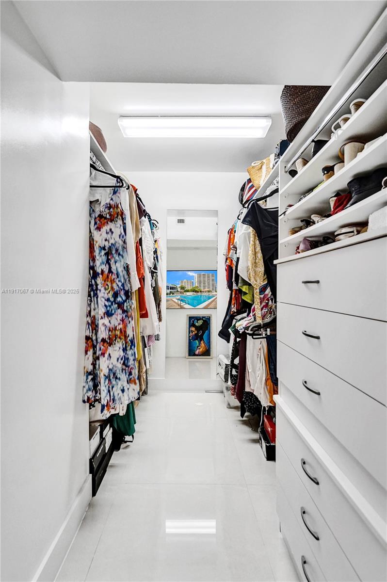 20281 East Country Club Drive, Unit 1114 Aventura, FL 33180 - Photo 50 of 87 a view of walk in closet with clothes