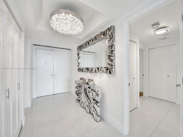a view of entryway with livingroom and chandelier