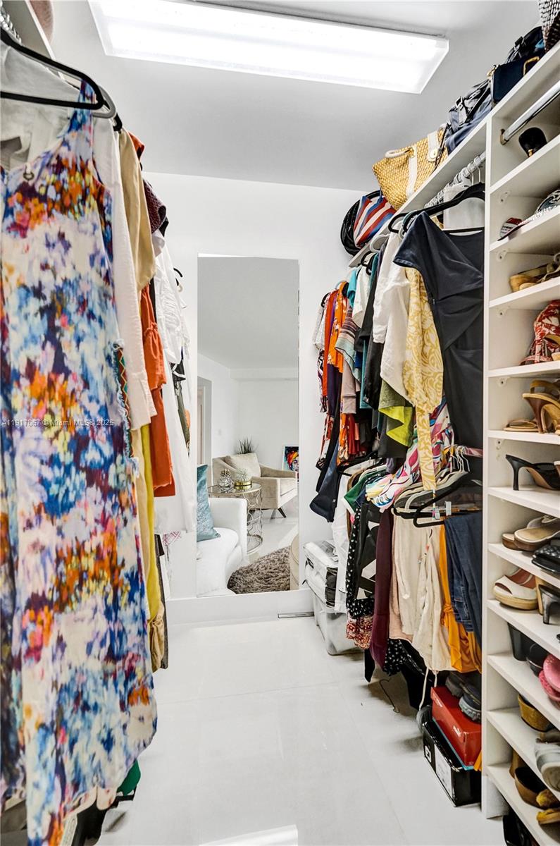 20281 East Country Club Drive, Unit 1114 Aventura, FL 33180 - Photo 51 of 87 a view of walk in closet with clothes and shoes