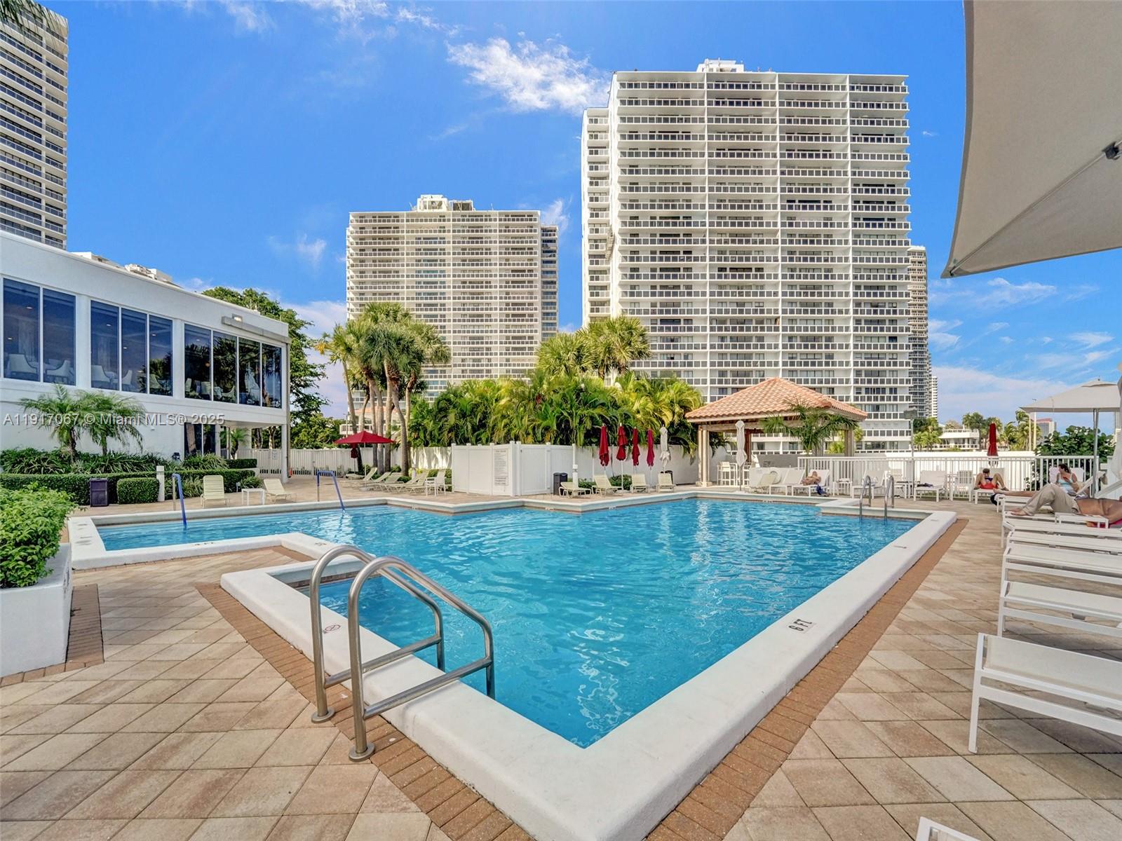 20281 East Country Club Drive, Unit 1114 Aventura, FL 33180 - Photo 67 of 87 a view of a swimming pool with chairs