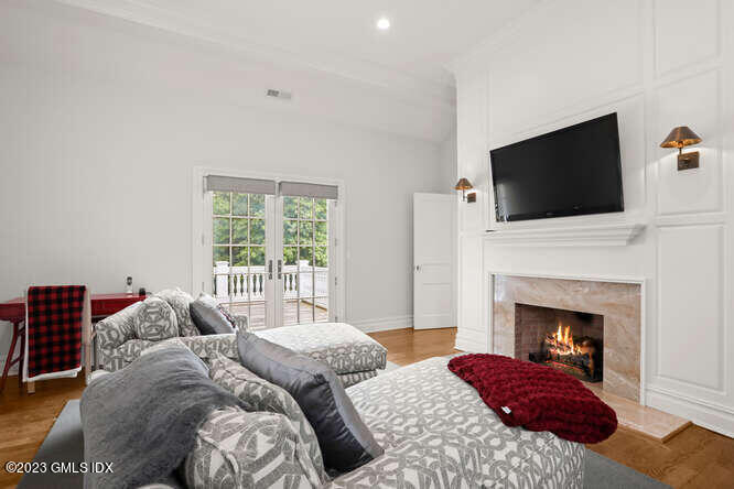 33 Boulder Brook Road Greenwich, CT 06830 - Photo 23 of 50 a bedroom with a balcony a bed and a fireplace