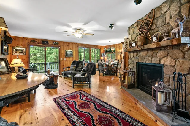 a living room with furniture a fireplace and a floor to ceiling window
