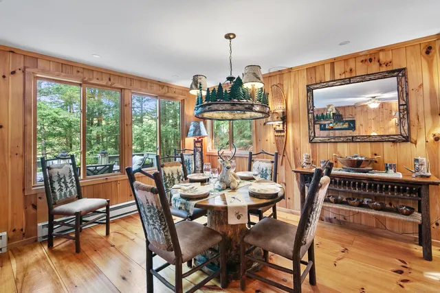 a dining room with furniture a chandelier and wooden floor