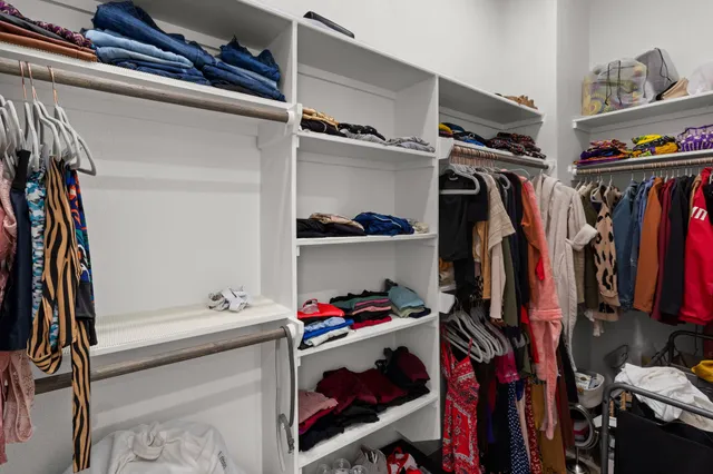 a view of walk in closet with clothes and shoes