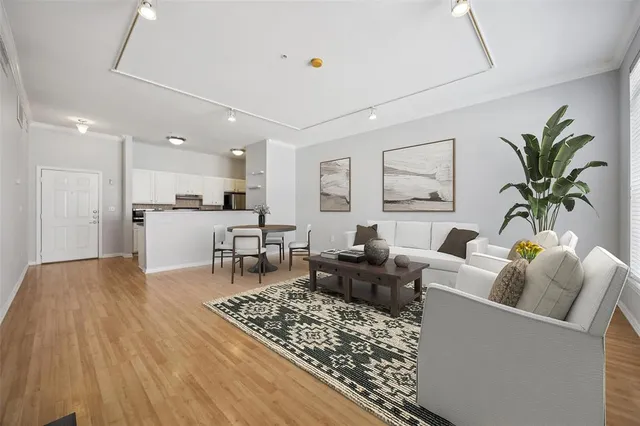 a living room with furniture and a dining table with kitchen view