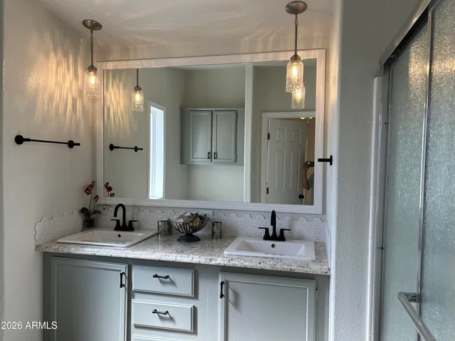 a bathroom with a granite countertop toilet sink and mirror