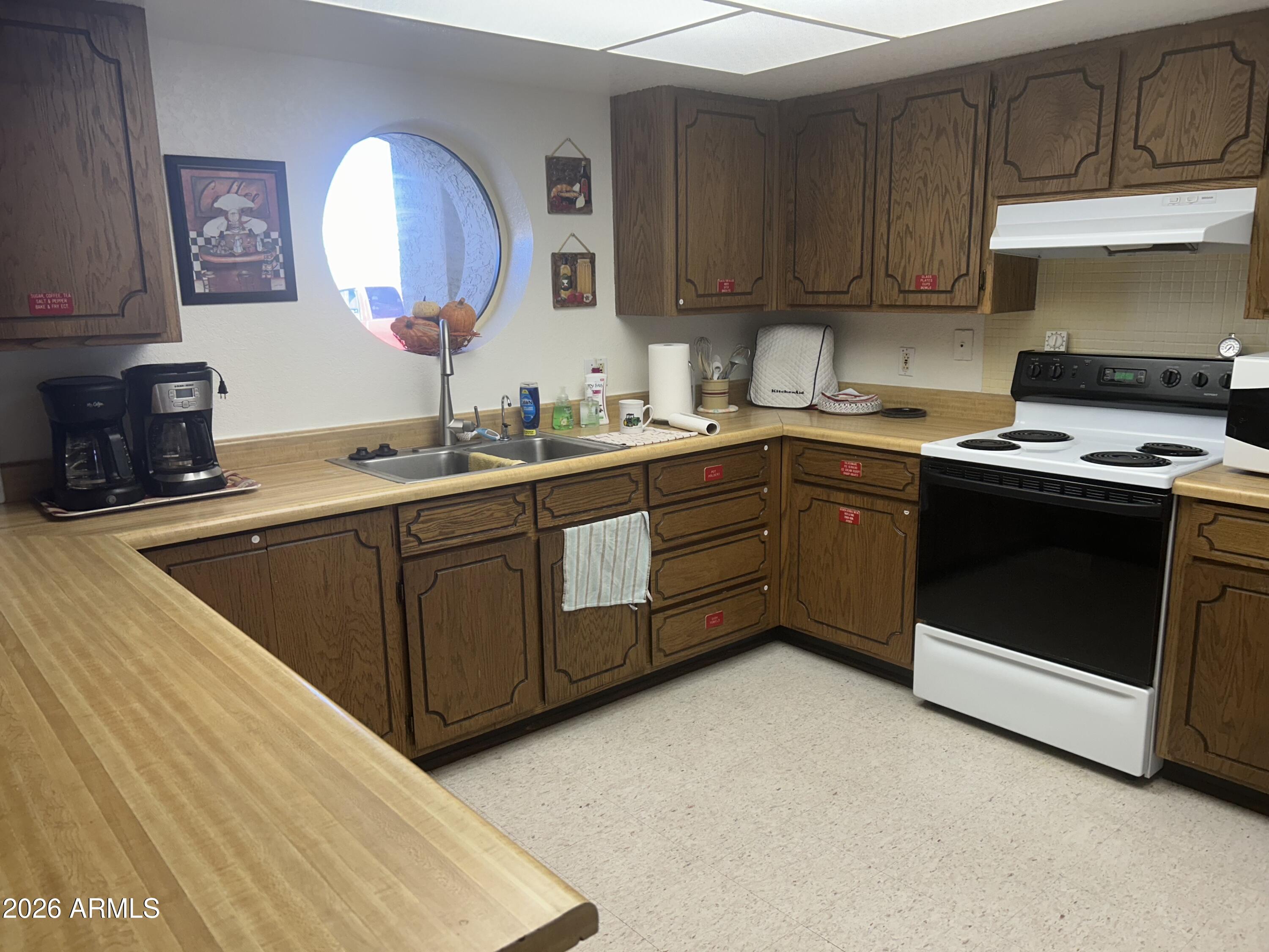 3500 South Tomahawk Road, Unit 217 Apache Junction, AZ 85119 - Photo 33 of 35 a kitchen with a sink stove and cabinets