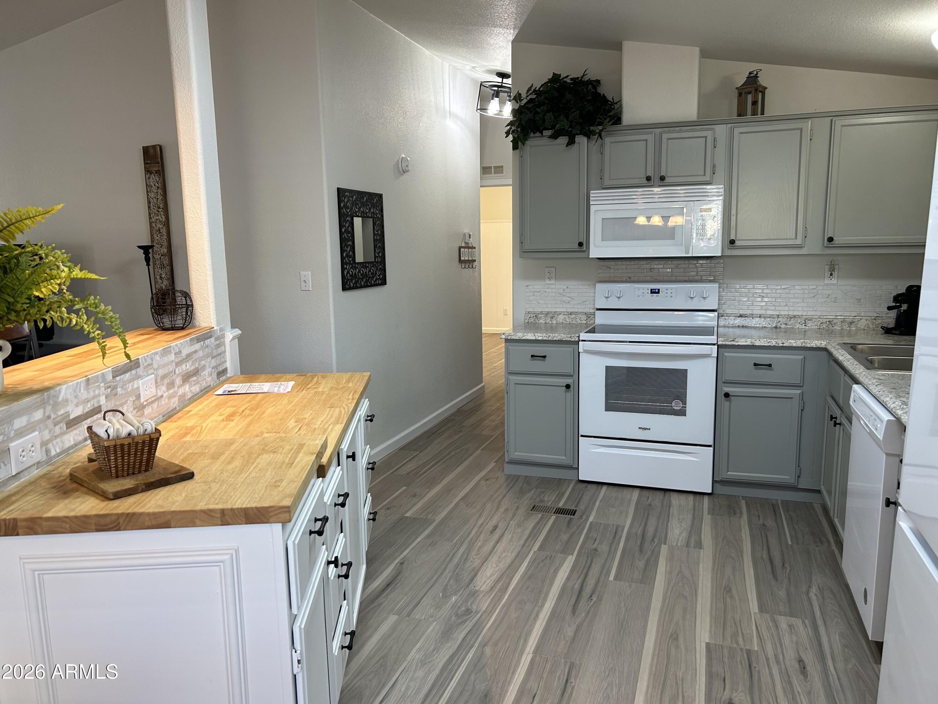 3500 South Tomahawk Road, Unit 217 Apache Junction, AZ 85119 - Photo 5 of 35 a kitchen with kitchen island a stove a sink and a refrigerator