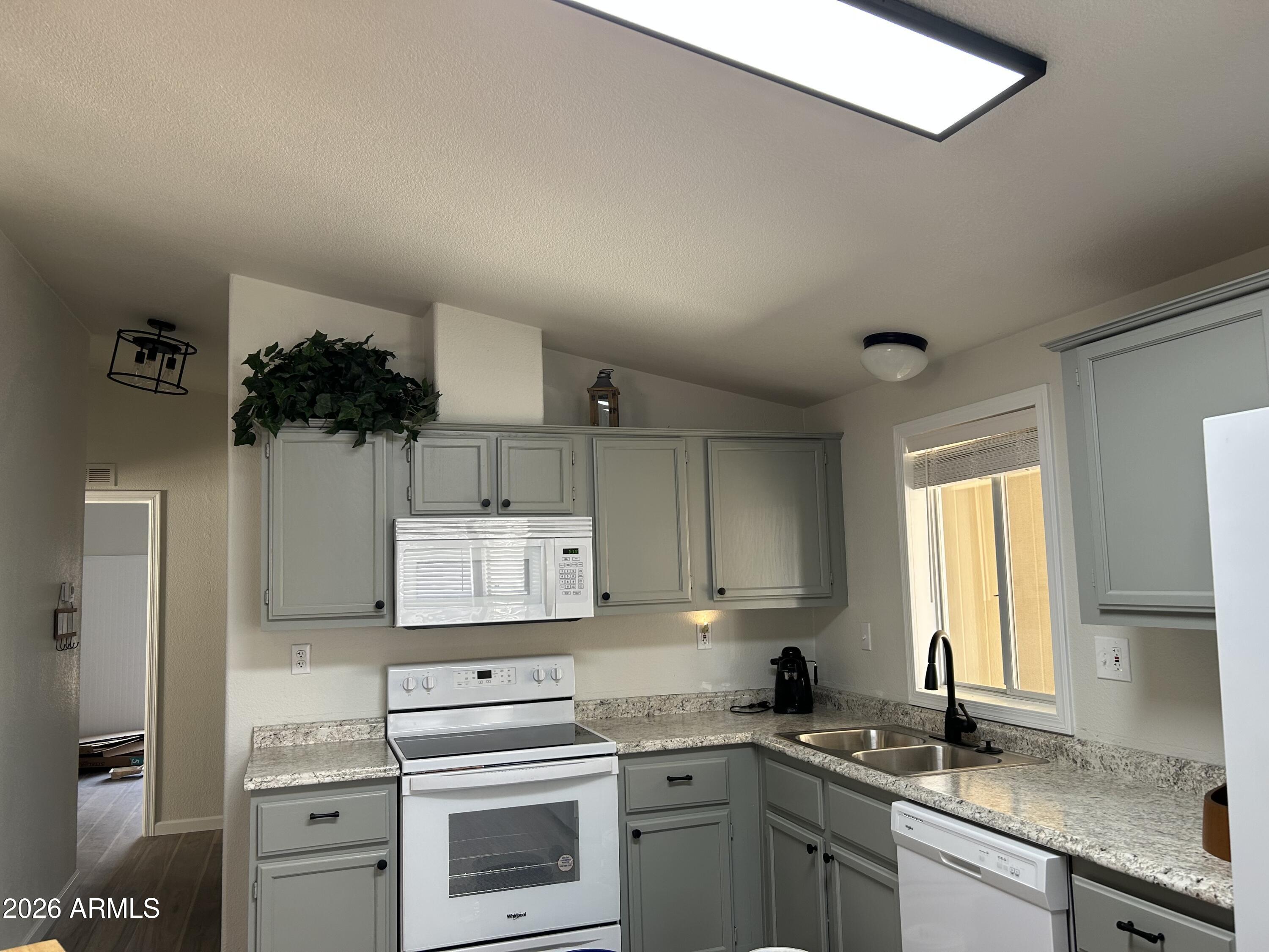 3500 South Tomahawk Road, Unit 217 Apache Junction, AZ 85119 - Photo 6 of 35 a kitchen with cabinets appliances a sink and a window