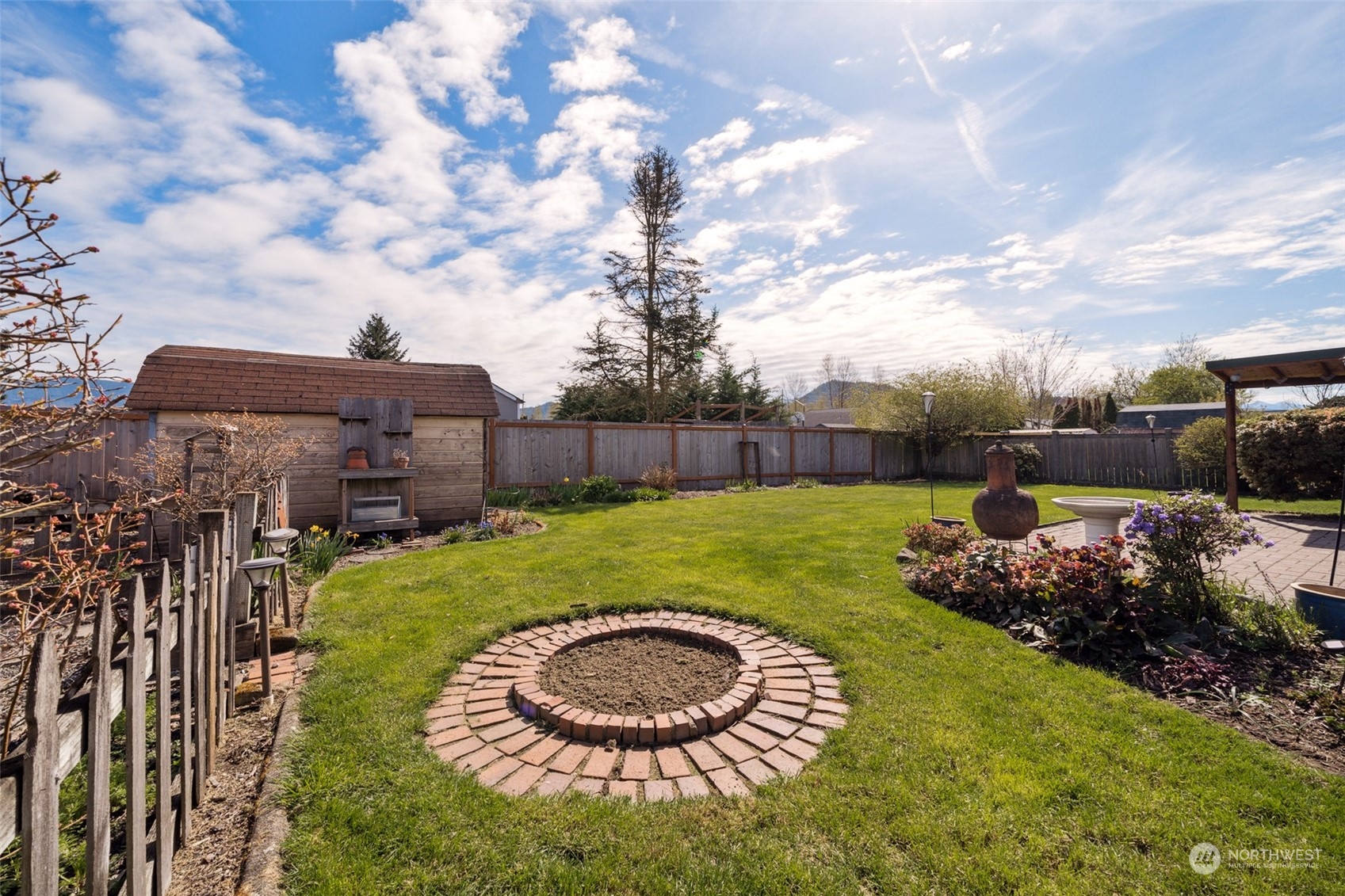 509 Harmony Lane Enumclaw, WA 98022 - Photo 20 of 22 a backyard of a house with a garden and barbeque oven
