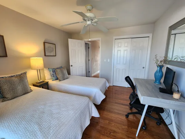 a bedroom with two beds and a desk