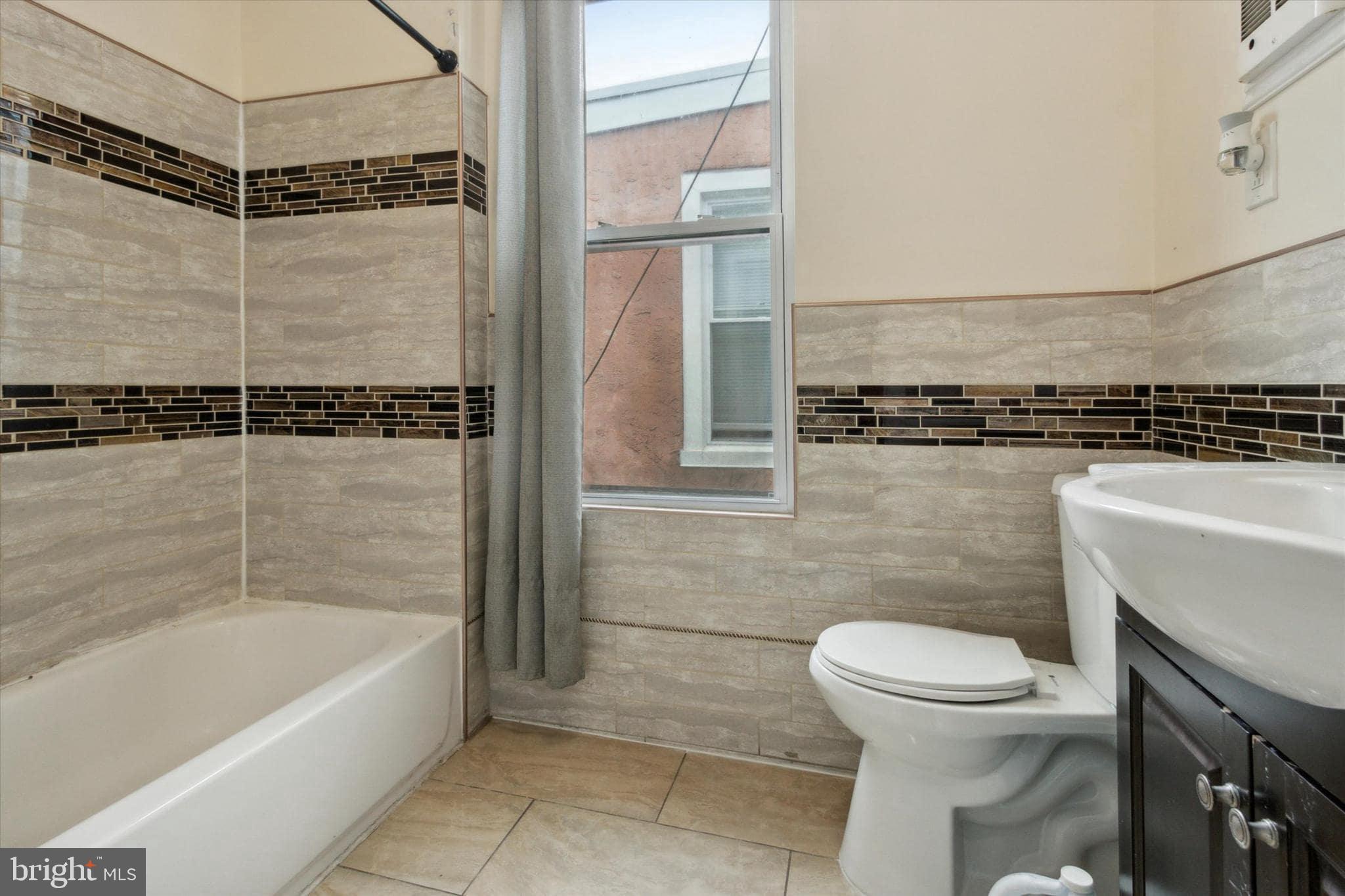 1933 Page Street Philadelphia, PA 19121 - Photo 17 of 19 a bathroom with a shower a toilet and bathtub