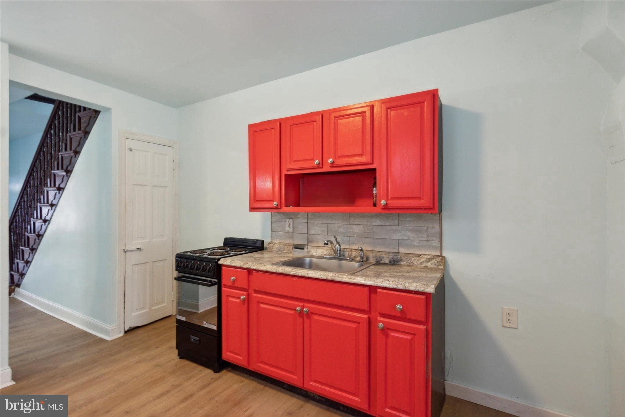 1933 Page Street Philadelphia, PA 19121 - Photo 5 of 19 a kitchen with stainless steel appliances granite countertop a sink stove and wooden floor