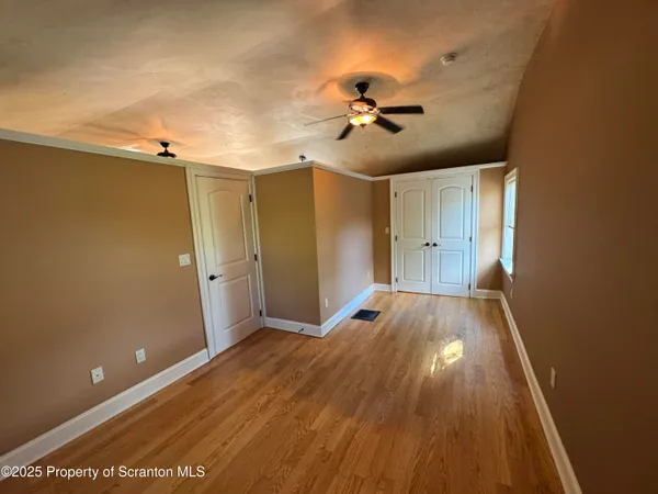 an empty room with a window and ceiling fan