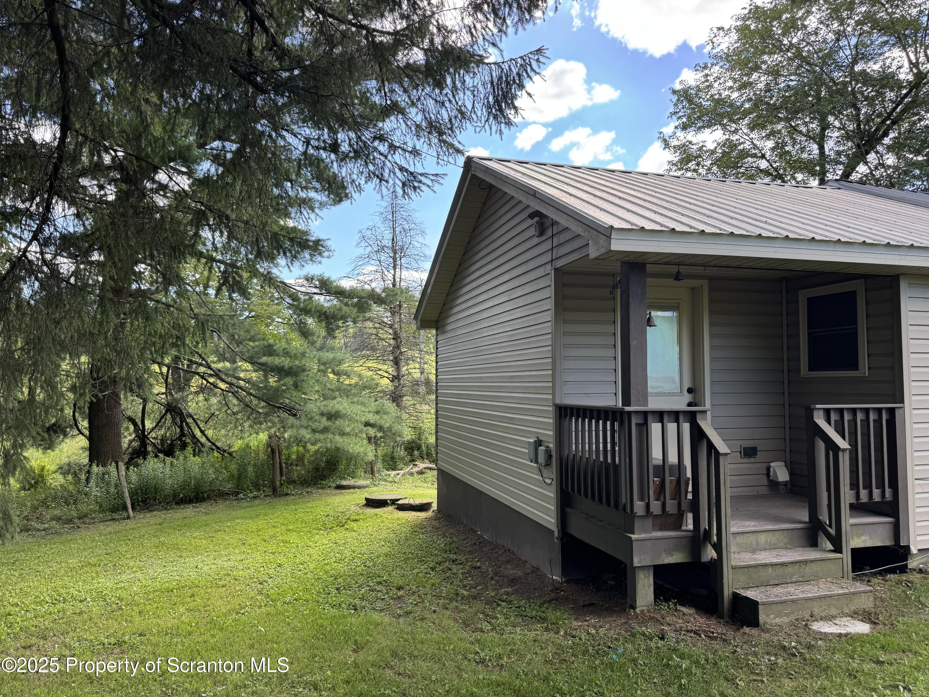 131 Ball Pond Road Thompson, PA 18465 - Photo 20 of 21 a view of backyard with deck and garden