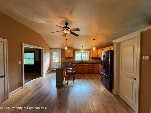 a view of a livingroom with furniture a ceiling fan and wooden floor