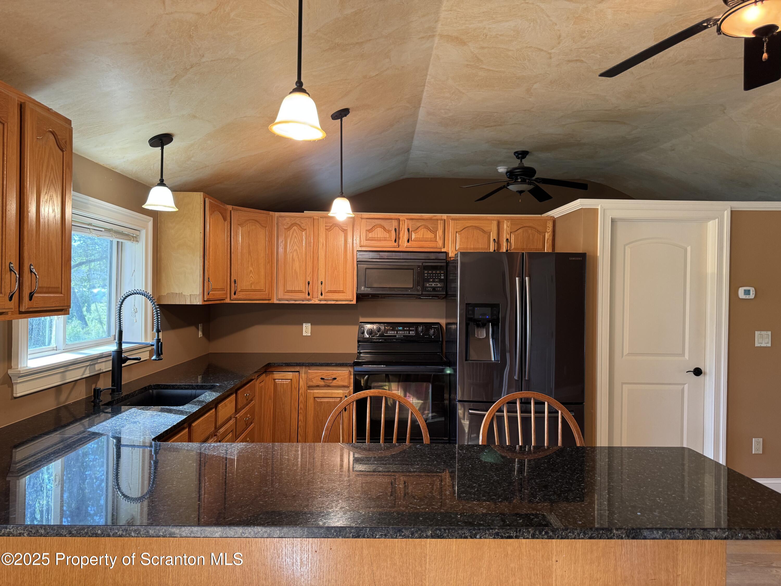 131 Ball Pond Road Thompson, PA 18465 - Photo 6 of 21 a kitchen with stainless steel appliances granite countertop a sink a stove and a refrigerator