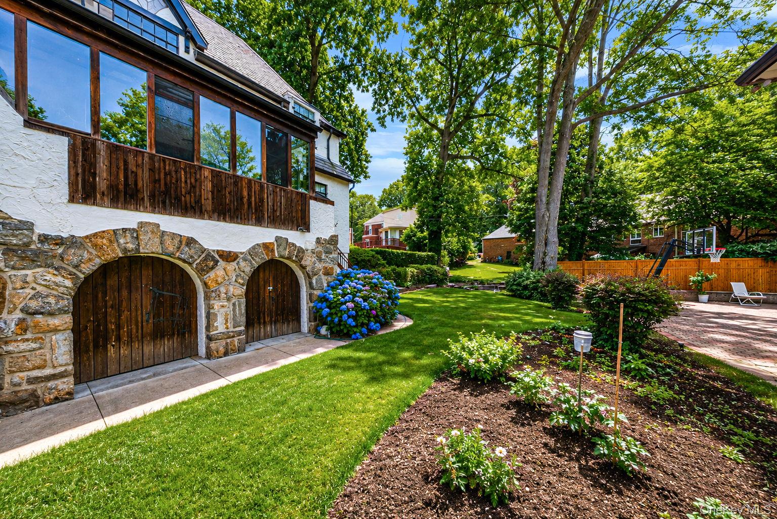 18240 Avon Road Queens, NY 11432 - Photo 28 of 30 Stone-clad arched garage doors with wood paneling