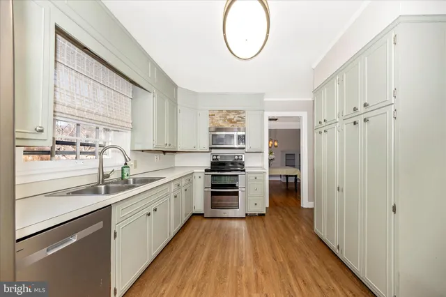 a kitchen with stainless steel appliances a stove sink and cabinets